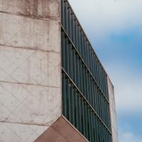 Concrete facade of Casa da Música concert hall with bird flying by, Porto, Portugal.